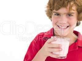 Young boy with glass of milk smiling