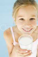 Young girl with glass of milk smiling