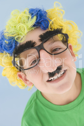 Young boy wearing clown wig and fake nose