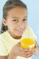 Young girl with glass of orange juice smiling