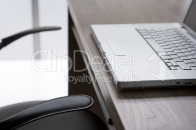 Empty Chair And Desk With Laptop Computer