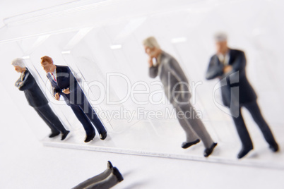 Row Of Businessman Figurines, With One Fallen Out Of Line