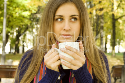 Attractive girl drinking coffee outdoors