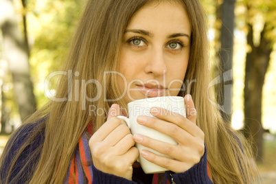 Attractive girl drinking coffee outdoors
