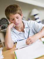 Young Boy Doing Homework In His Room