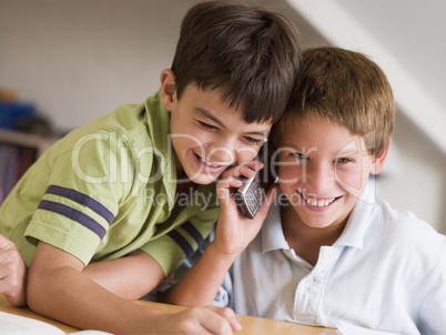 Two Young Boys Calling Someone On A Cellphone