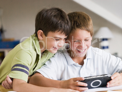 Two Young Boys Playing With A Handheld Video Game