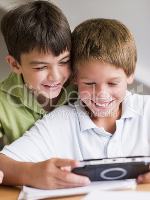 Two Young Boys Playing With A Handheld Video Game