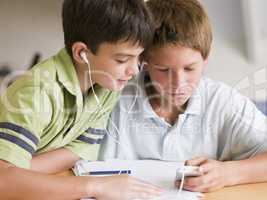 Two Young Boys Distracted From Their Homework, Playing With An M