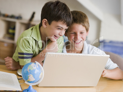 Two Young Boys Using A Laptop At Home