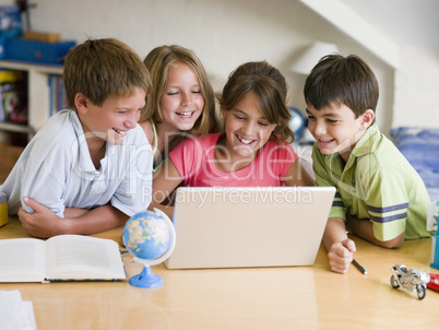 Group Of Young Children Doing Their Homework On A Laptop