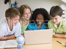 Group Of Young Children Doing Their Homework On A Laptop