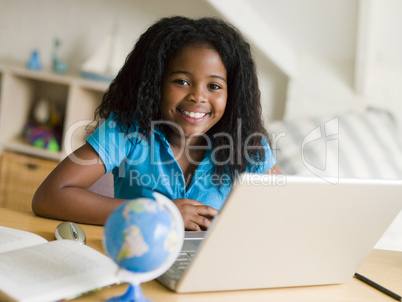 Young Girl Doing Her Homework On A Laptop