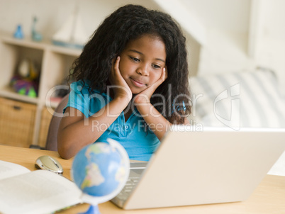 Young Girl Doing Her Homework On A Laptop