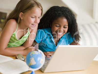 Two Young Girls Doing Their Homework On A Laptop