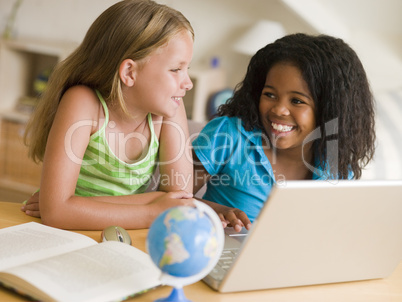 Two Young Girls Doing Their Homework On A Laptop