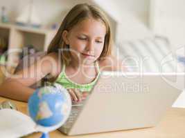 Young Girl Doing Homework On A Laptop
