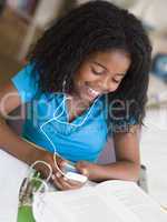 Young Girl Distracted From Her Homework, Playing With An MP3 Pla