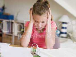 Young Girl Doing Her Homework With Her Head In Her Hands
