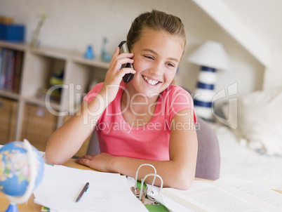 Young Girl Distracted From Her Homework, Talking On A Cellphone
