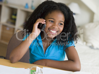 Young Girl Distracted From Her Homework, Talking On A Cellphone