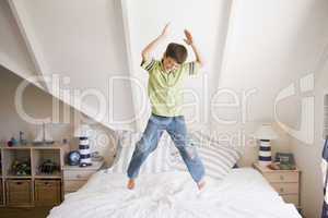 Young Boy Jumping On His Bed