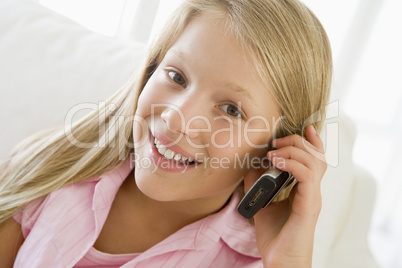 Young Girl Sitting On A Sofa Talking On A Cellphone