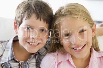 Brother And Sister Sitting Side By Side On A Couch