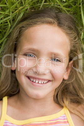 Young Girl Lying Down On The Grass