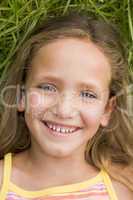 Young Girl Lying Down On The Grass