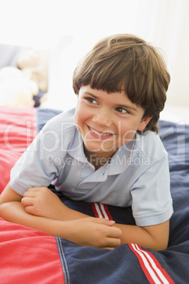 Young Boy Lying Down On His Bed