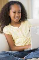 Young Girl Sitting On A Sofa, Using A Laptop
