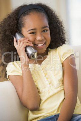 Young Girl Sitting On A Sofa, Talking On A Telephone