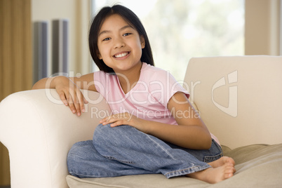 Young Girl Sitting On A Sofa At Home