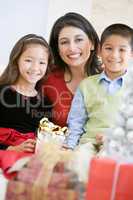 Mother With Her Son And Daughter Holding Christmas Gifts