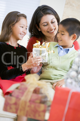 Mother Sitting With Her Son And Daughter,Exchanging Christmas Gi