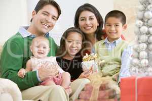 Family With New Born,Sitting On Sofa,Holding Christmas Gift