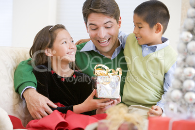 Father Being Given A Christmas Present By His Daughter And Son