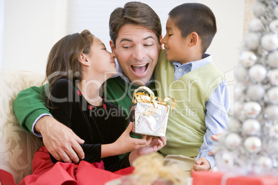 Father Being Given A Christmas Present By His Daughter And Son