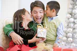 Father Being Given A Christmas Present By His Daughter And Son