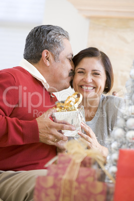 Middle Aged Couple Affectionately Sitting And Holding Christmas