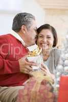 Middle Aged Couple Affectionately Sitting And Holding Christmas