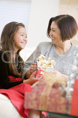 Grandmother And Granddaughter Exchanging Christmas Gifts