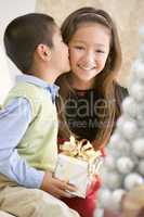 Brother Kissing His Sister On The Cheek,And Holding A Christmas
