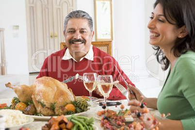Father And His Adult Daughter Sitting Down For Christmas Dinner