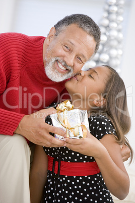 Grandfather Giving His Granddaughter A Christmas Present