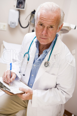 Middle Aged Doctor Writing On His Clipboard