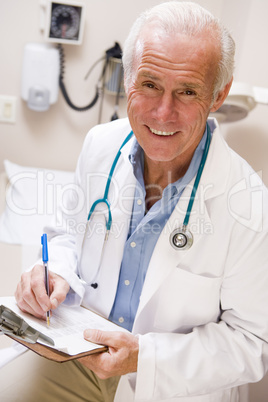 Middle Aged Doctor Writing On His Clipboard