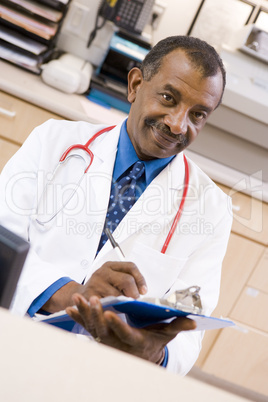 A Doctor Writing On A Clipboard At The Reception Area Of A Hospi