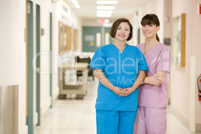 Two Female Nurses Standing In A Hospital Corridor